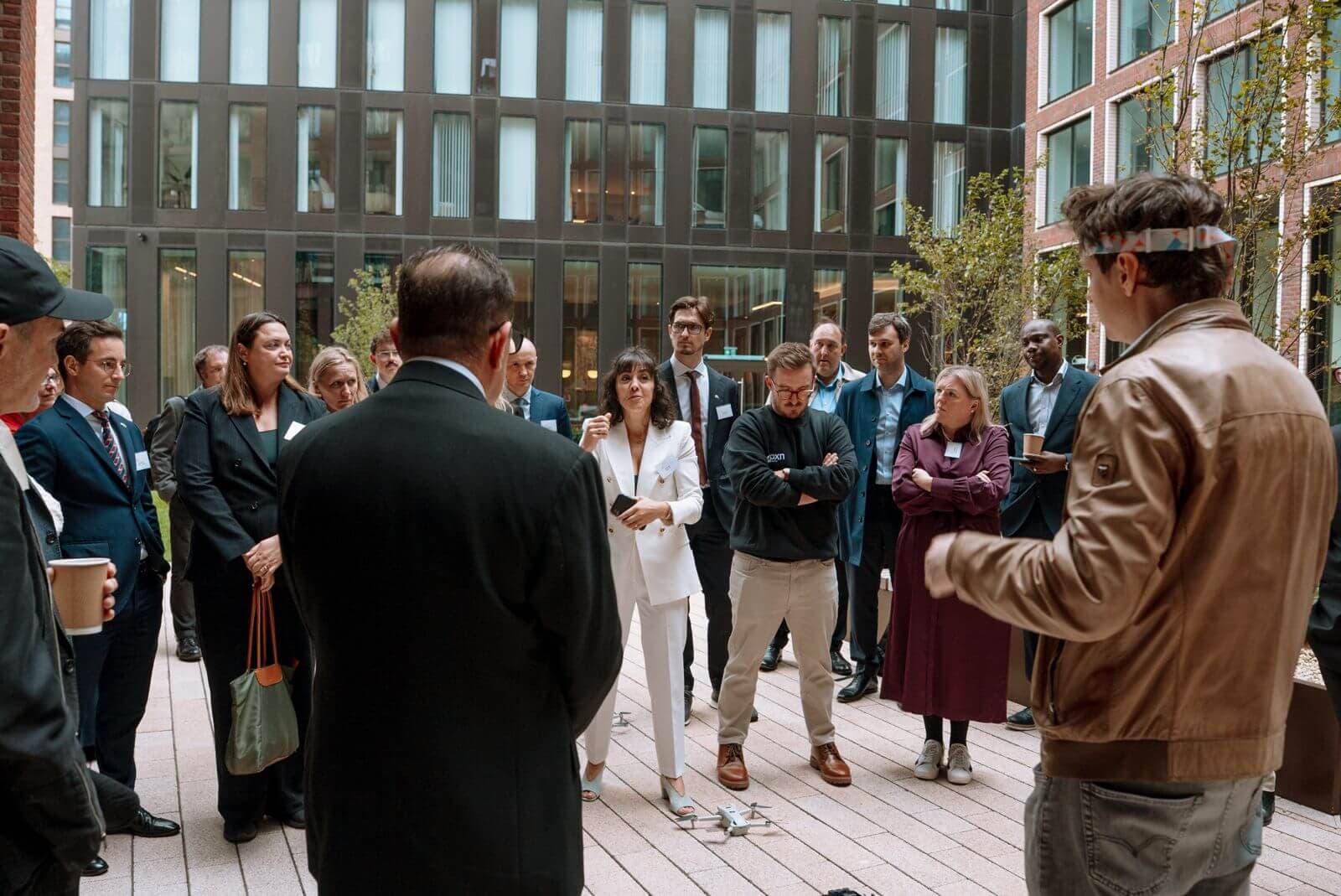 Guests gathered for a live outdoor demonstration around a small drone