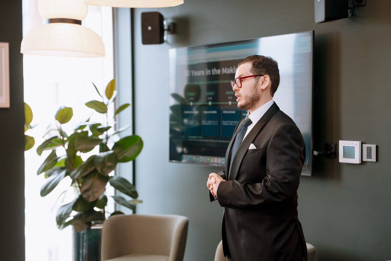 A speaker beside a presentation at the summit